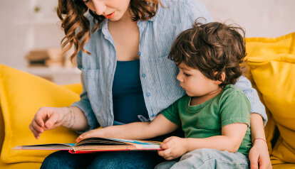 Foto: Mutter und kleiner Sohn, die zusammen ein Bilderbuch lesen