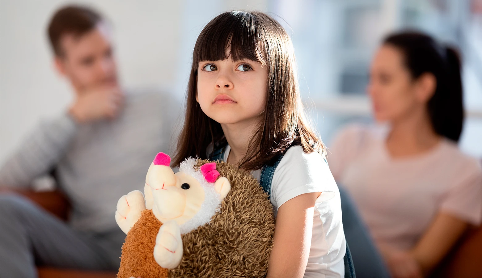 Foto: Trauriges Mädchen mit streitenden Eltern.