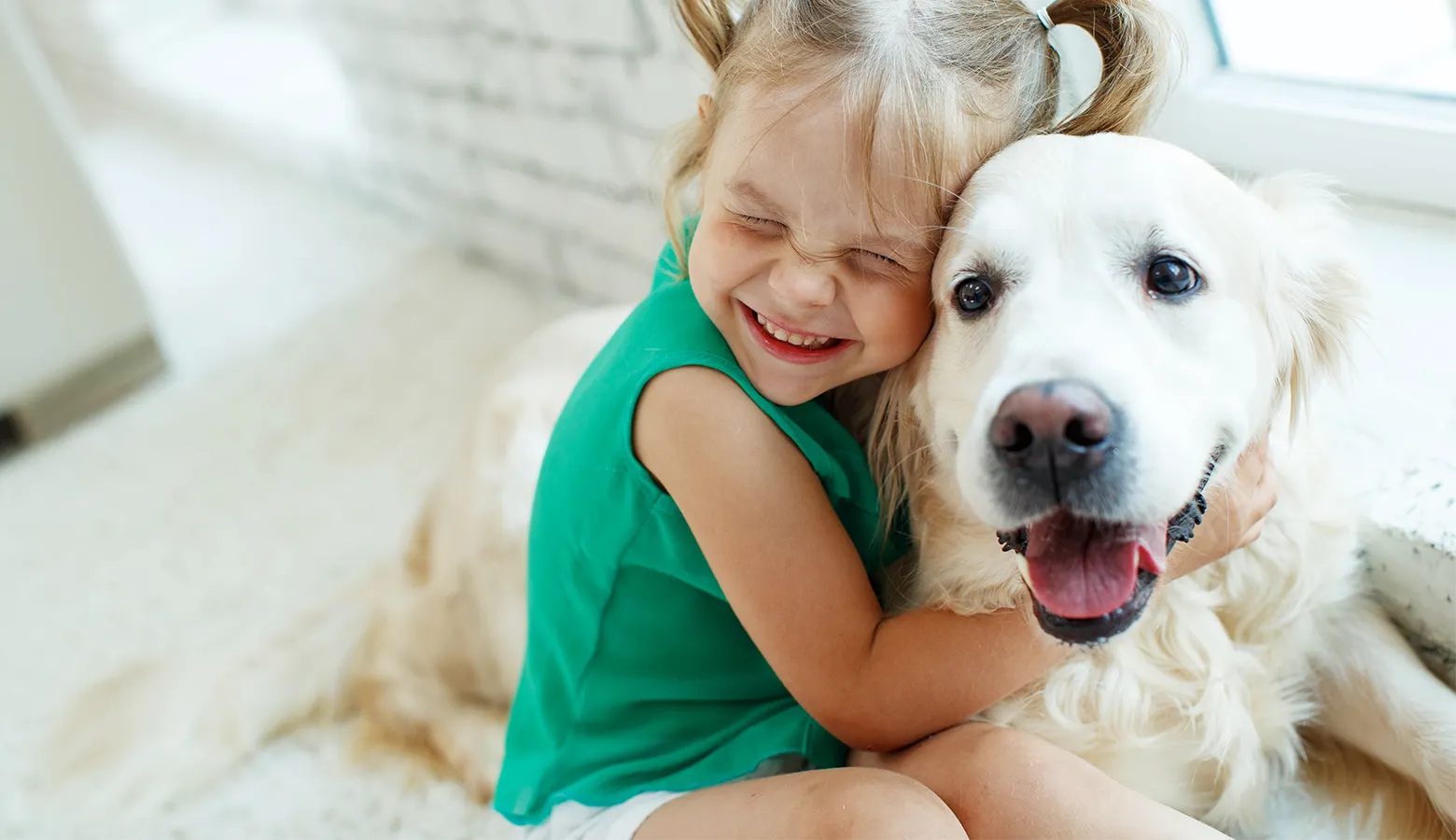 Maedchen umarmt einen großen weißen Hund
