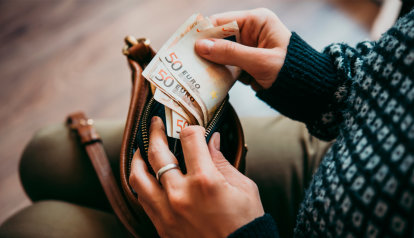 Foto: Frau holt vier 50 Euroscheine aus der Handtasche
