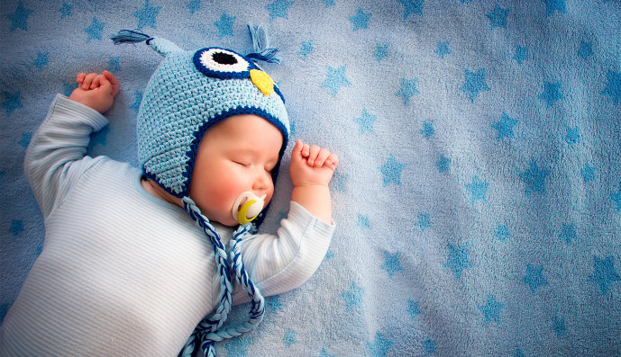 Foto: Viert Monate altes Baby liegt schlafend auf einer Decke