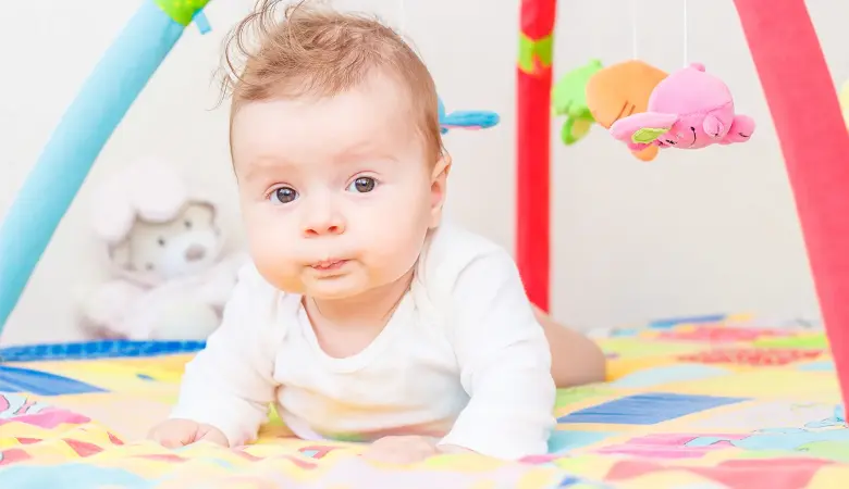 Baby liegt auf einer Krabbeldecke