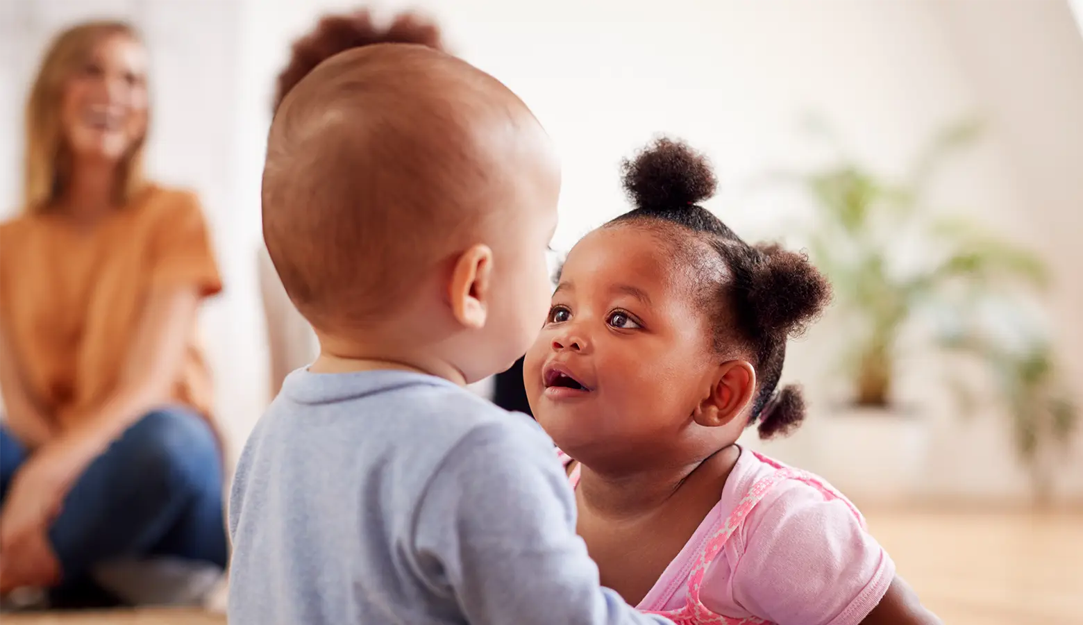 Zwei Babys in eine Spielgruppe sitzen sich gegenüber