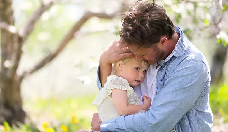 Ein Vater hält seine traurige Tochter im Arm