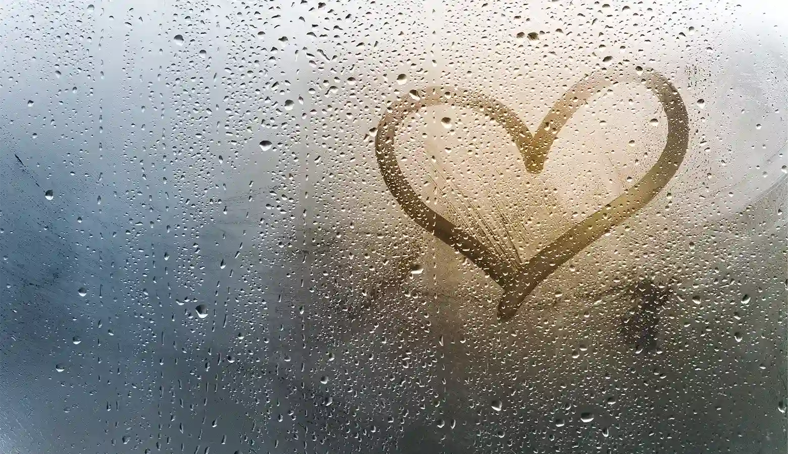 Ein Herz wurde auf ein nasses Fenster gemalt.