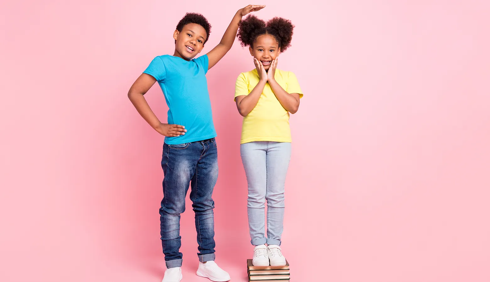 Zwei Kinder stehen nebeneinander und schauen, wie groß sie sind