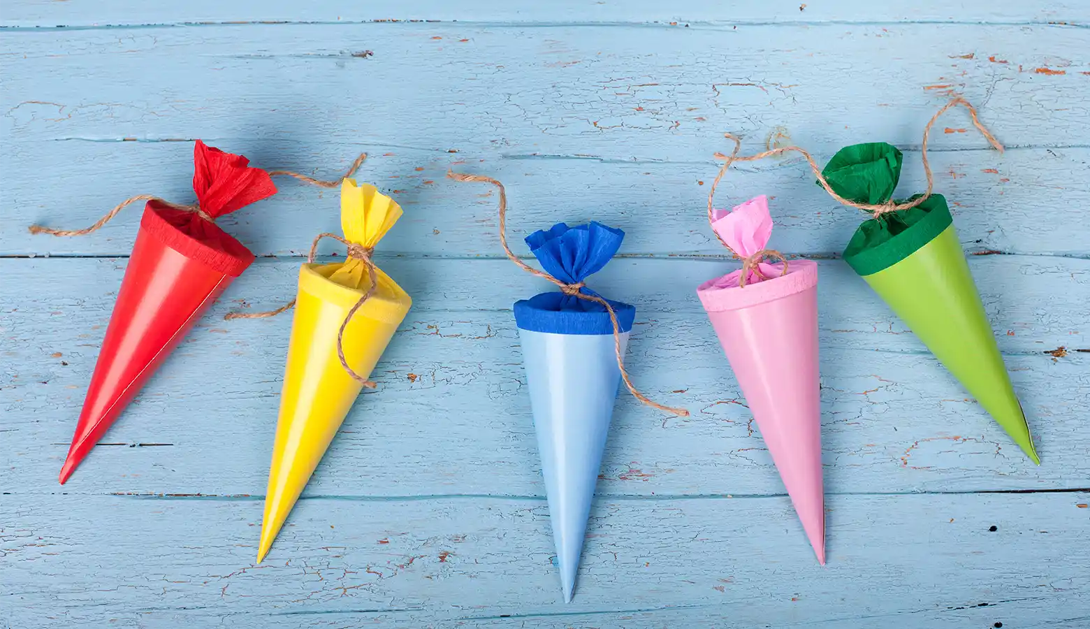 Fünf bunte Schultüten nebeneinander aufgereiht.