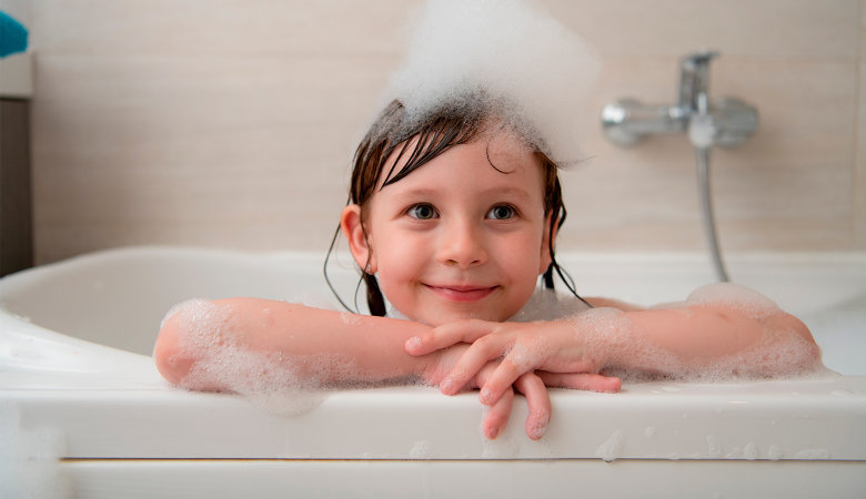 Foto: Kind in der Badewanne mit Schaum auf dem Kopf