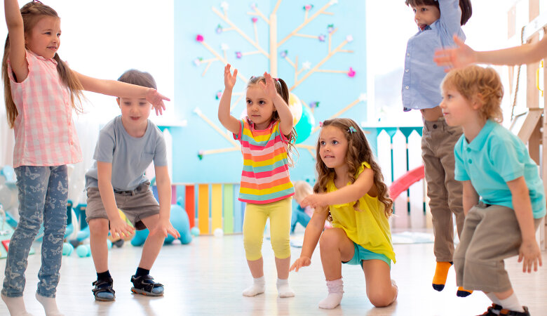 Foto: Vorschulkinder-Gruppe in der Kita, die im Kreis miteinander Tanzen