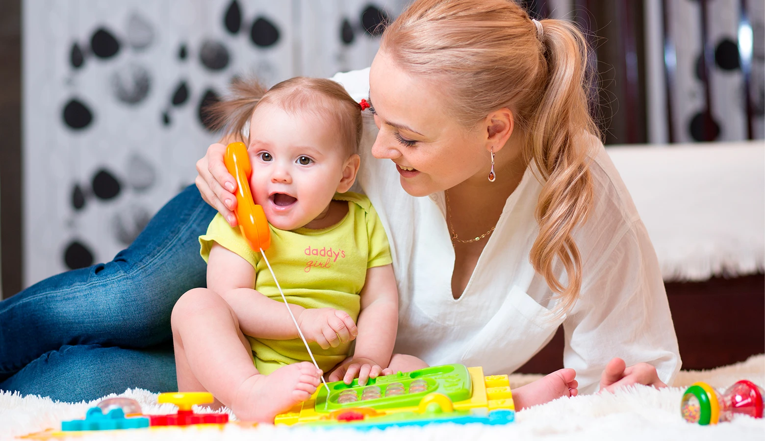 Foto: Kleines Mädchen und Mutter spielen mit einem Kindertelefon