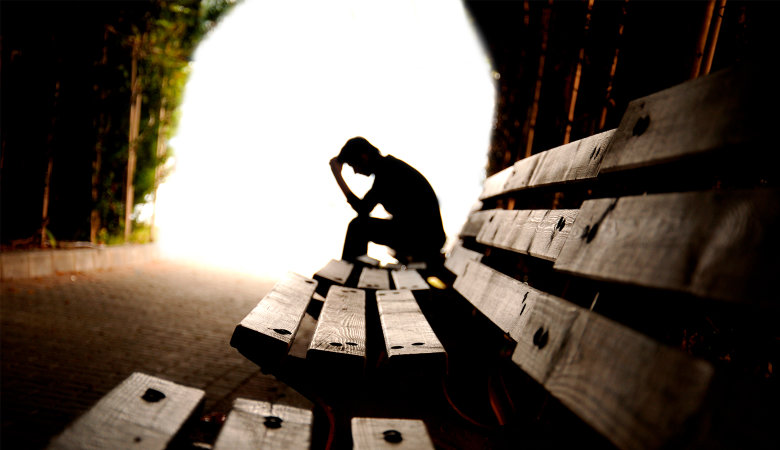 Foto: Teenager Junge sitzt in einem Tunnel auf Holzplanken
