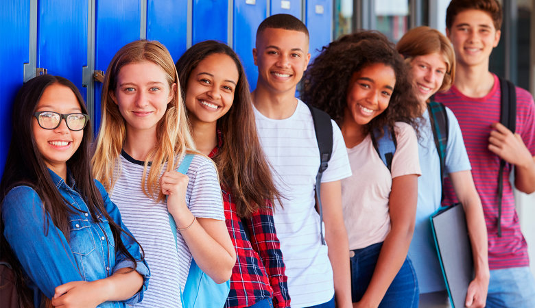 Foto: Sieben Teenagerschülerinnen und Schüler lächeln in die Kamera