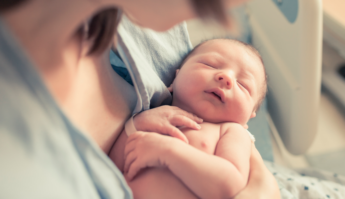 Foto: Neugeborener Junge, der in den Armen der Mutter ruht